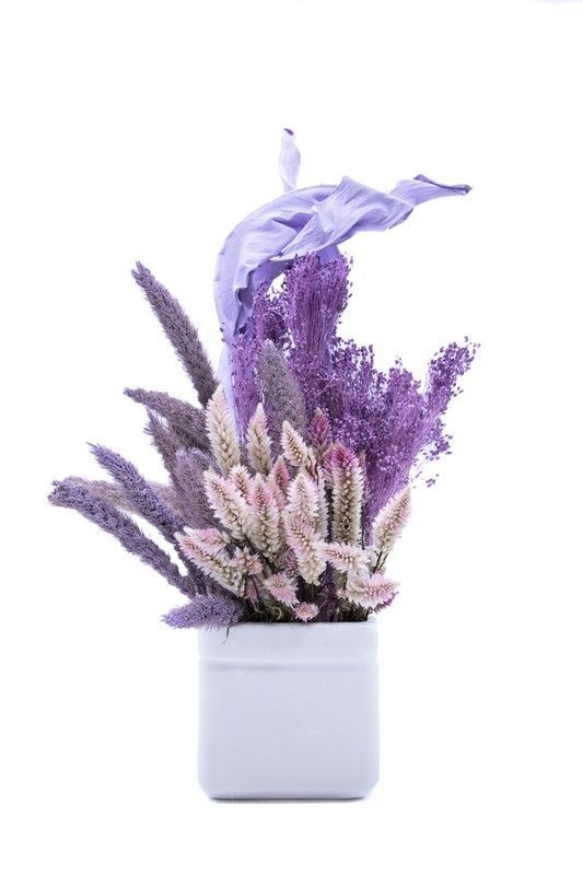 Elegante centro de cerámica blanca con flores lilas y rosadas