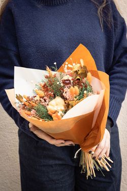 Luminoso ramo de flores secas y preservadas en tonos naranjas y rosados