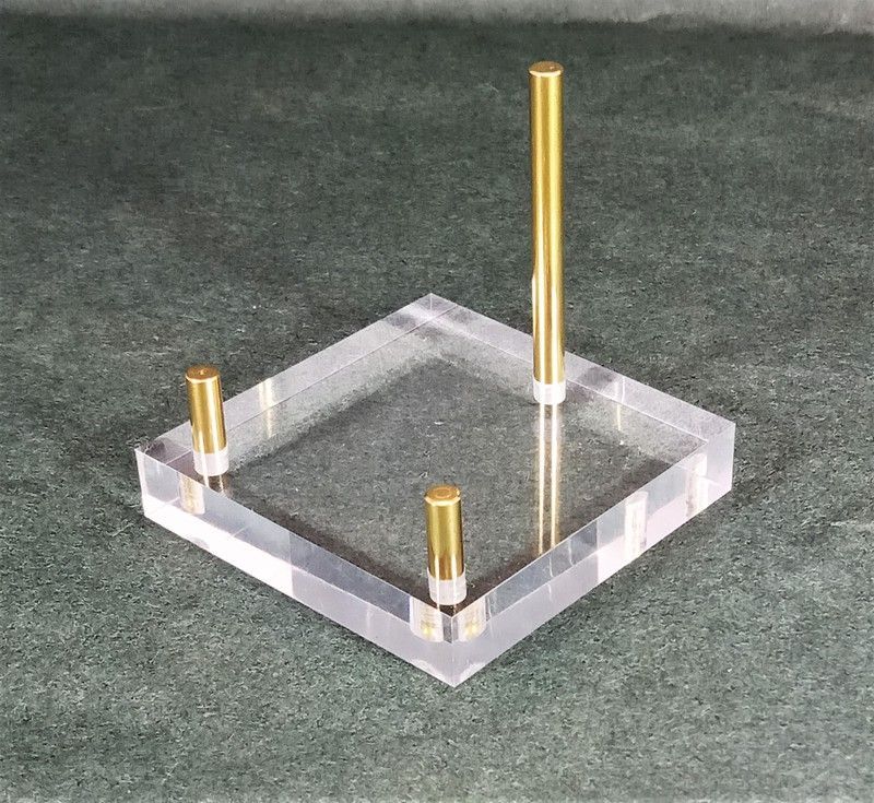 Soporte metacrilato de 50x50x10 con 3 varillas en latón dorado